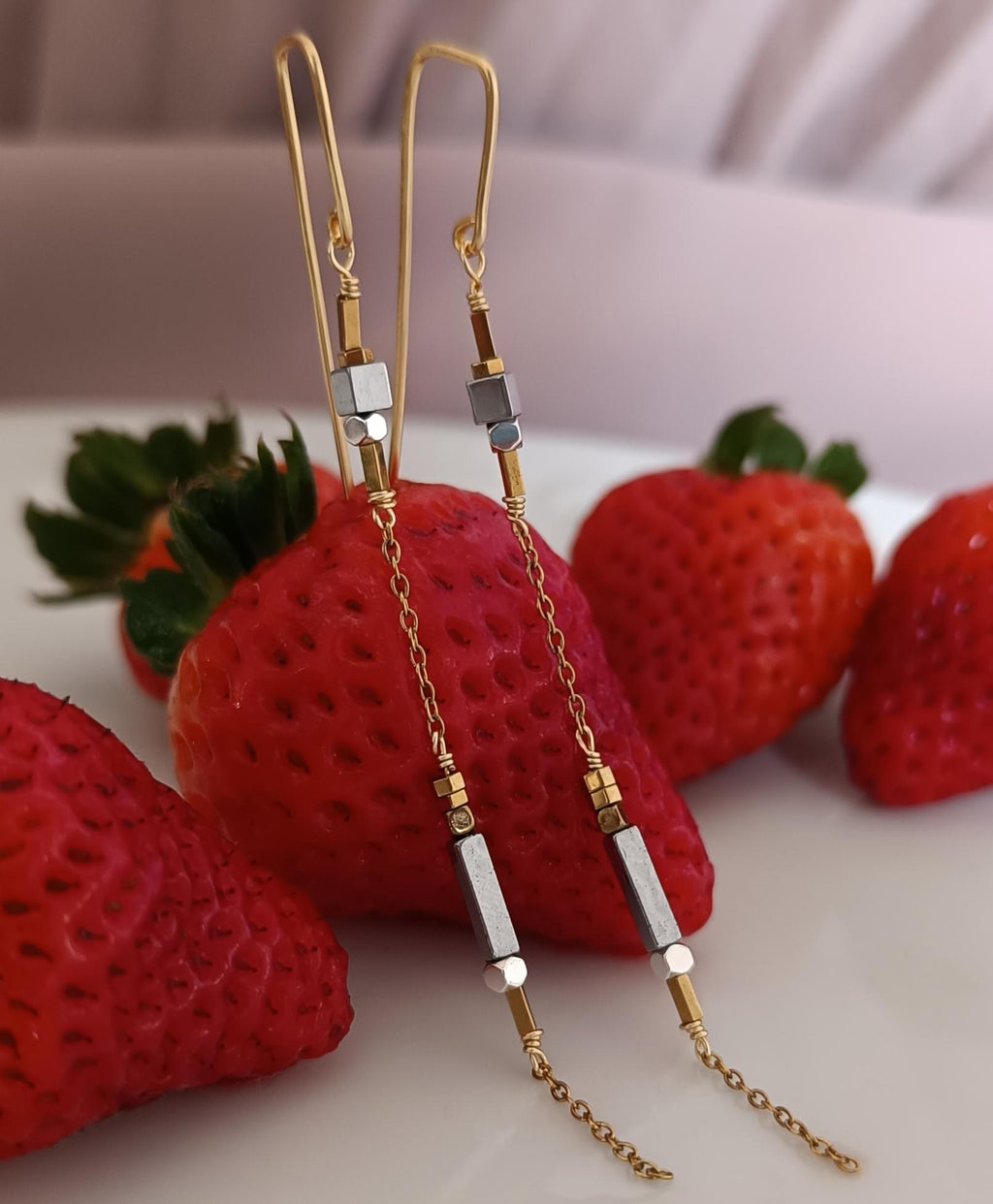 Minimalist long gold threader earrings with hematite beads, handcrafted with 18k gold-plated wire. Lightweight, modern jewelry on neutral background
