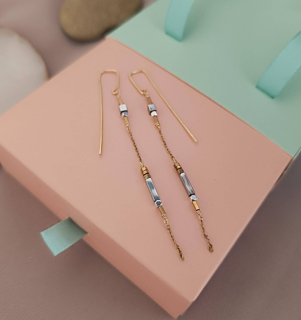 Minimalist long gold threader earrings with hematite beads, handcrafted with 18k gold-plated wire. Lightweight, modern jewelry on neutral background.