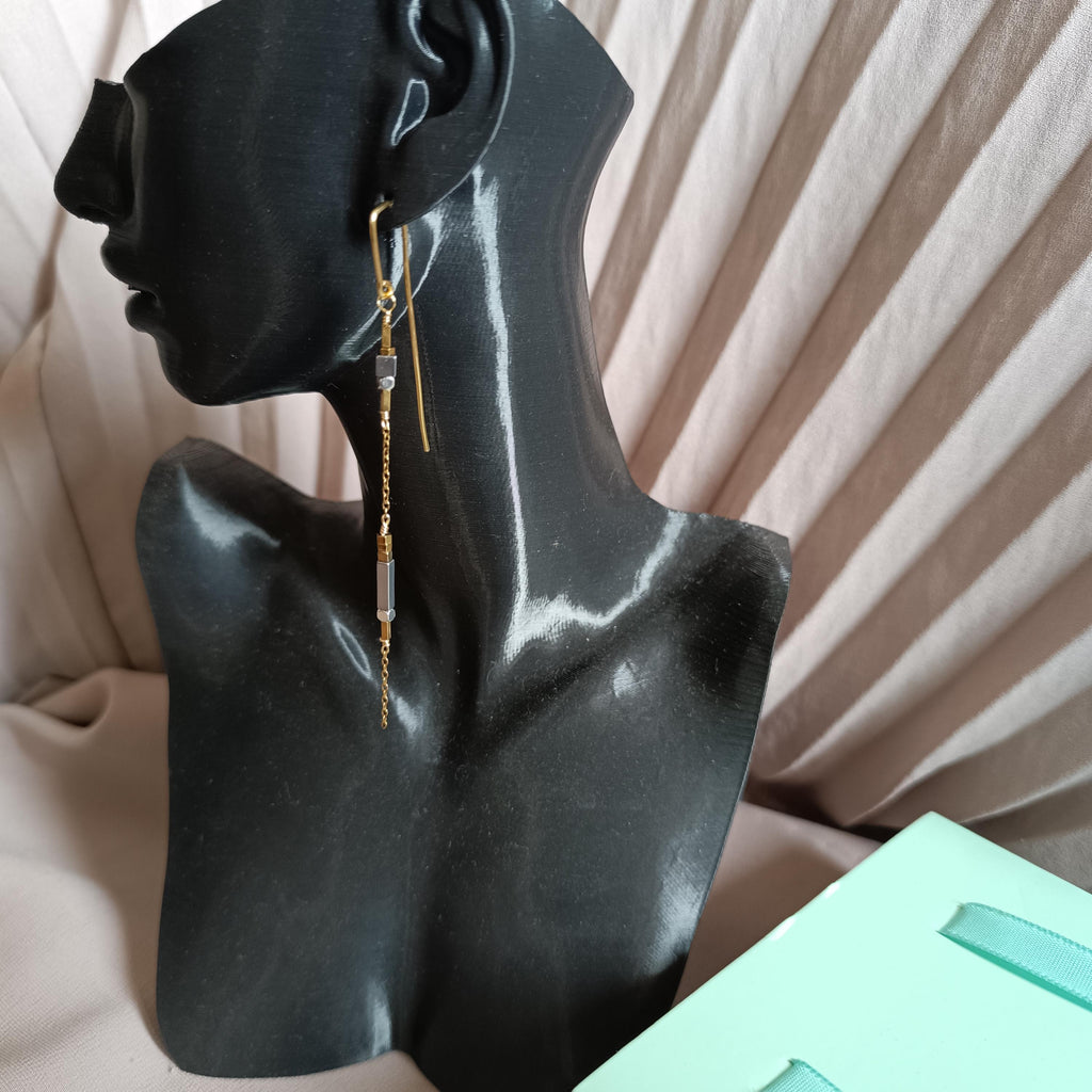 Minimalist long gold threader earrings with hematite beads, handcrafted with 18k gold-plated wire. Lightweight, modern jewelry on neutral background.
