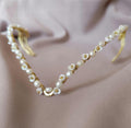 delicate handmade brass tiara with pearls, styled in an elegant twist braid hairstyle